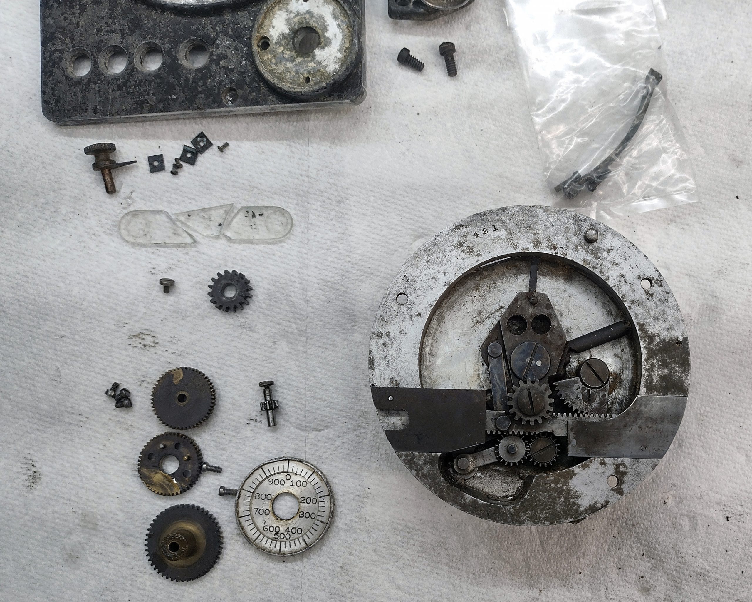 Mitchell Standard 46 - replacment back plate disassembled, with the dissolved shutter control before repairs, as well as the Veeder Root foot frame counter and footage counter clock drive gears.