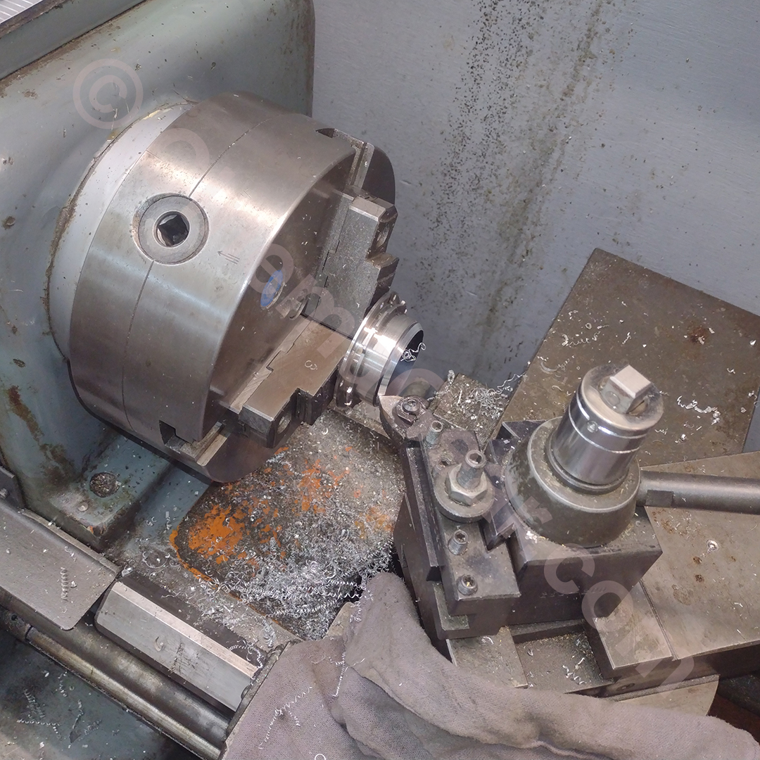 Machining to reduce height of beauty ring and put 45 degree bevel on the back.