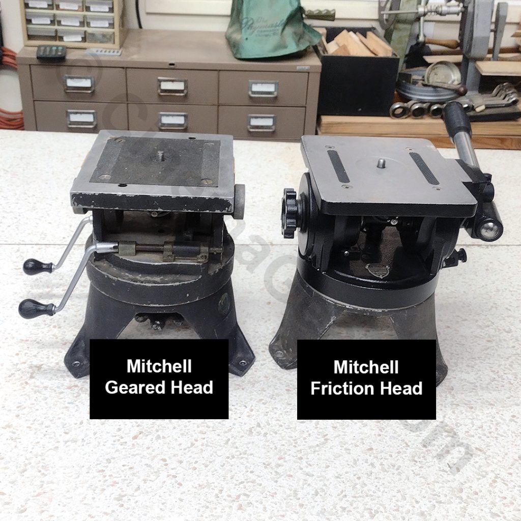A side by side view of a Mitchell Geared head and a Mitchell Friction Head. The geared head sits on the left of the photo and is operated by a pair of cranks that control the pan and tilt axes. The friction head sits on the right of the photo and is operated by a telescoping handle.