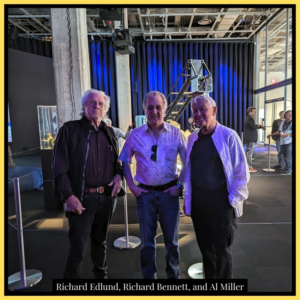 Richard Edlund, Richard Bennett, and Al Miller standing in front of the model of the Millennium Falcon and the Dykstraflex in the Spielberg Family Gallery at the Academy Museum of Motion Pictures.