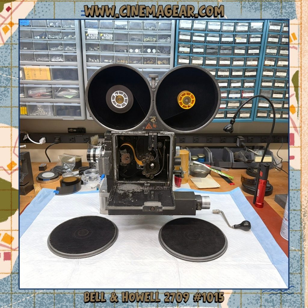 A view of Bell & Howell 2709 serial number 1015 threaded with film and the camera door and magazine doors open.